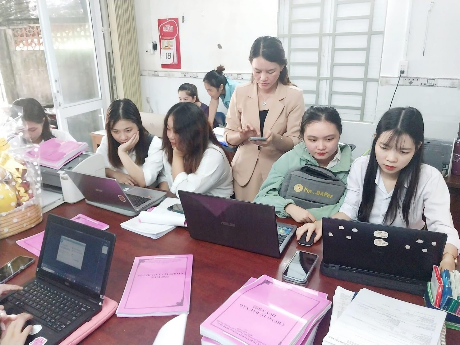 ''A group of women sitting at a table with laptops

Description automatically generated''